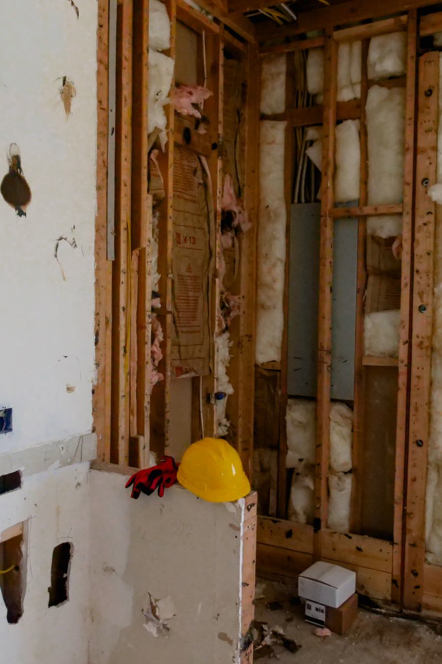 An interior wall opened to exposed timber studs and insulation during a renovation