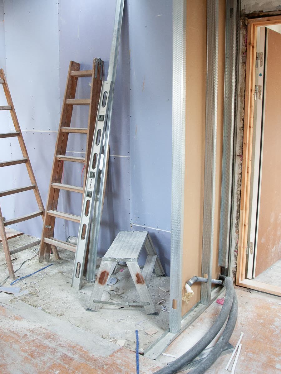 Stepladders and dust sheeting set up in a room prepared for work
